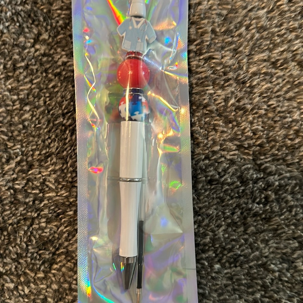 Hand beaded pen. Black ink. Focal bead is a scrub shirt.